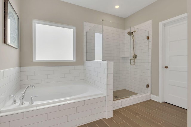 full bathroom with recessed lighting, wood finish floors, a shower stall, and a garden tub