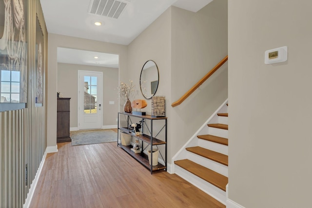 foyer featuring stairway, wood finished floors, visible vents, baseboards, and recessed lighting