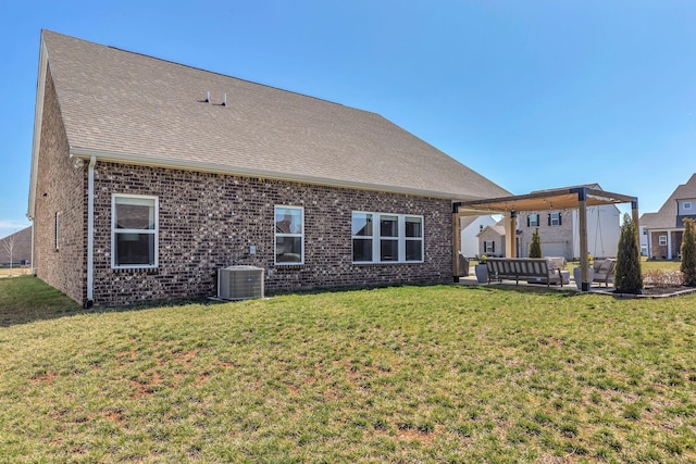 back of property featuring a yard, brick siding, and central AC unit