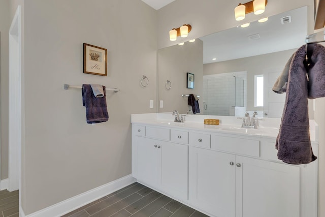 full bath with a sink, visible vents, baseboards, and a stall shower