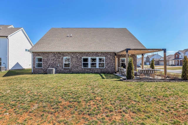 back of property featuring central air condition unit, brick siding, a lawn, and a patio area