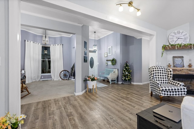 living room with crown molding, baseboards, and wood finished floors