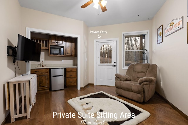 kitchen with built in microwave, dark wood finished floors, light countertops, fridge, and a ceiling fan