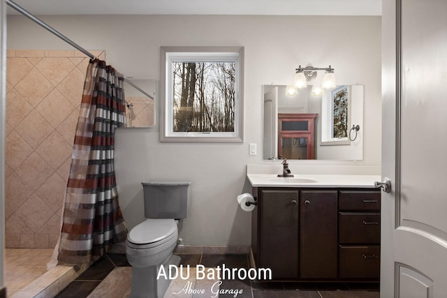 full bath featuring toilet, a shower stall, tile patterned flooring, baseboards, and vanity