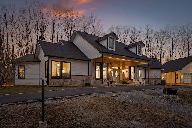 view of front of home with a porch and stone siding