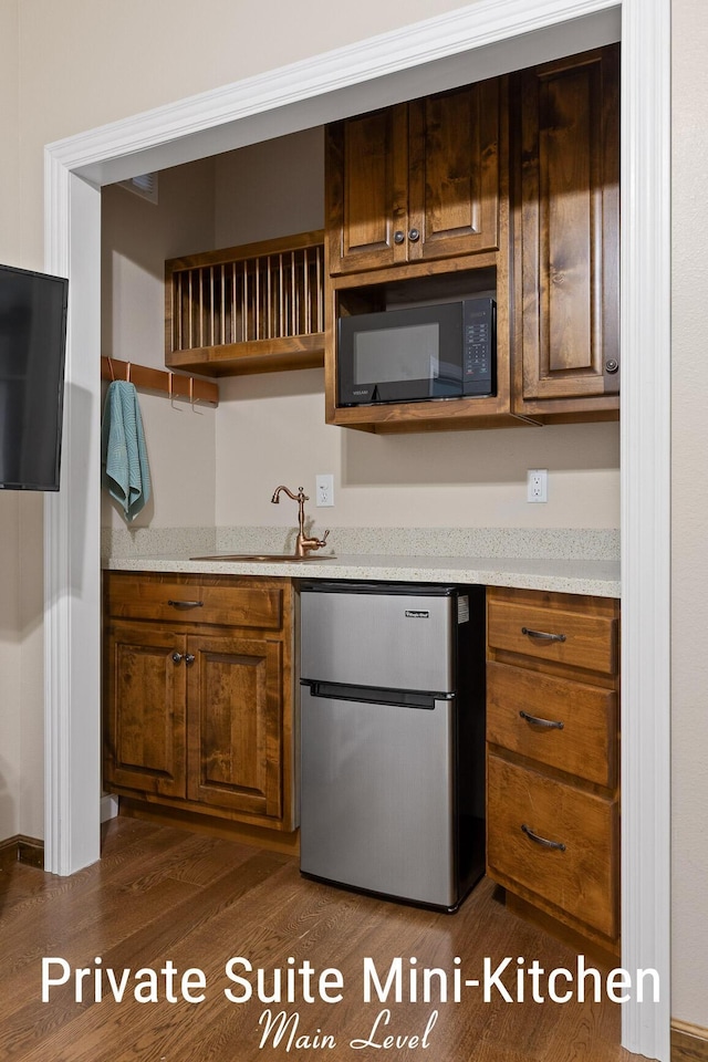 kitchen featuring fridge, open shelves, dark wood-style floors, and black microwave