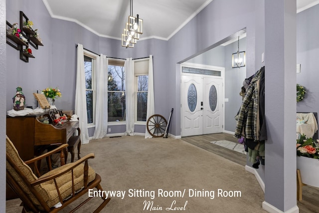 entrance foyer featuring baseboards, carpet floors, a chandelier, and ornamental molding