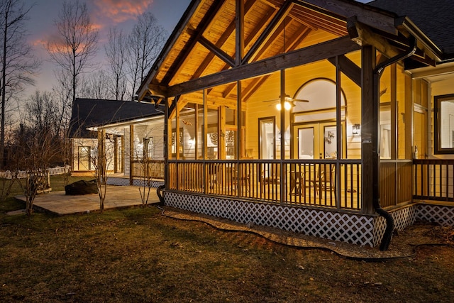 back of house at dusk with a ceiling fan and a patio area