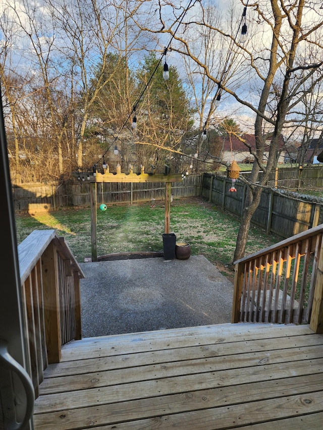 wooden terrace featuring a patio area, a yard, and a fenced backyard