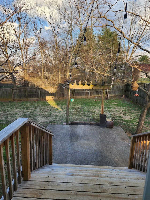 wooden terrace with a patio area, a lawn, and a fenced backyard