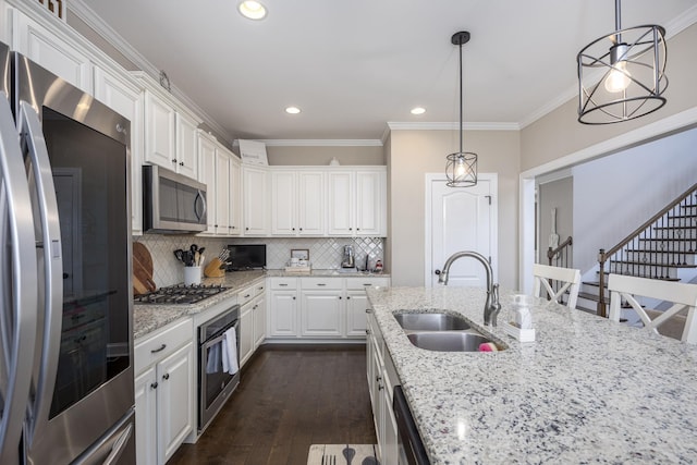 kitchen with dark wood-type flooring, ornamental molding, a sink, white cabinetry, and appliances with stainless steel finishes