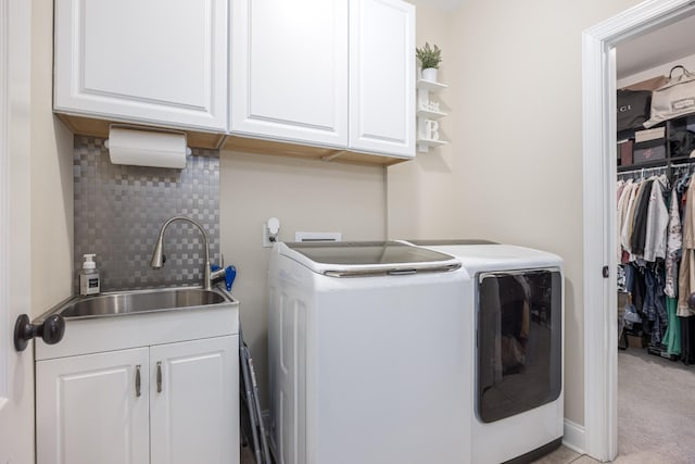 laundry room with washer and dryer, light carpet, cabinet space, and a sink