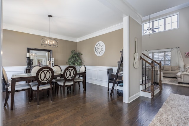 dining room with dark wood-style floors, stairs, and crown molding