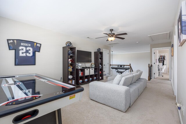 carpeted living area with visible vents, attic access, and ceiling fan