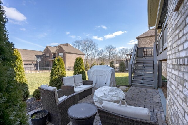 view of patio featuring stairs, grilling area, fence, and an outdoor hangout area