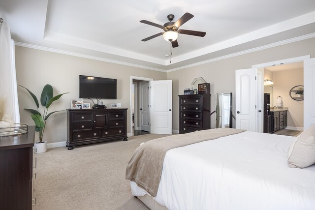 carpeted bedroom with a tray ceiling, ornamental molding, baseboards, and ceiling fan