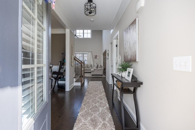 entryway with baseboards, dark wood-style floors, stairs, and ornamental molding