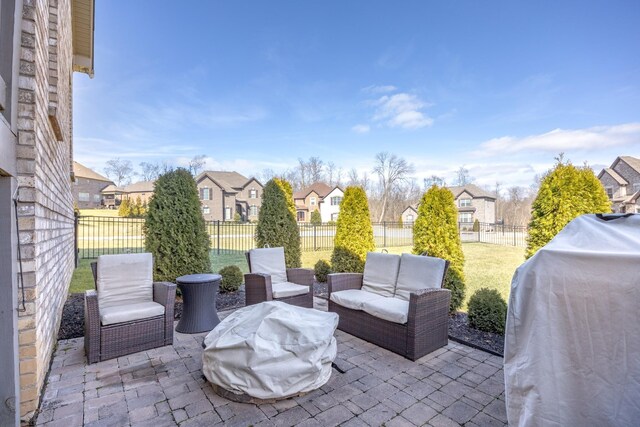 view of patio featuring outdoor lounge area, a fenced backyard, a residential view, and grilling area