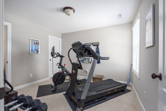 workout room featuring carpet flooring, baseboards, visible vents, and plenty of natural light