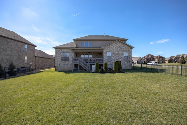 back of property with stairs, a yard, a fenced backyard, and brick siding