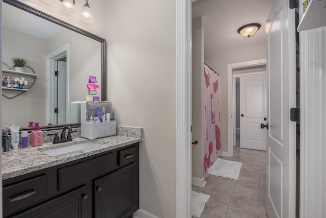 full bath with vanity, a shower with shower curtain, baseboards, and tile patterned flooring