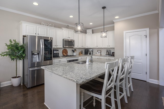 kitchen with dark wood finished floors, a sink, decorative backsplash, white cabinets, and appliances with stainless steel finishes