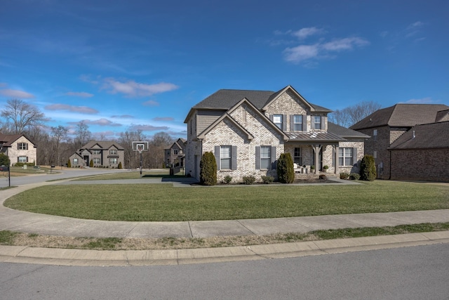 view of front facade with a standing seam roof, a front lawn, brick siding, and metal roof