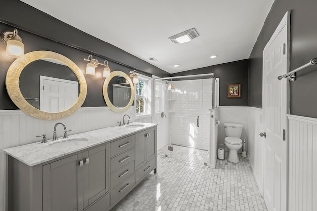 bathroom featuring a shower stall, visible vents, wainscoting, and a sink