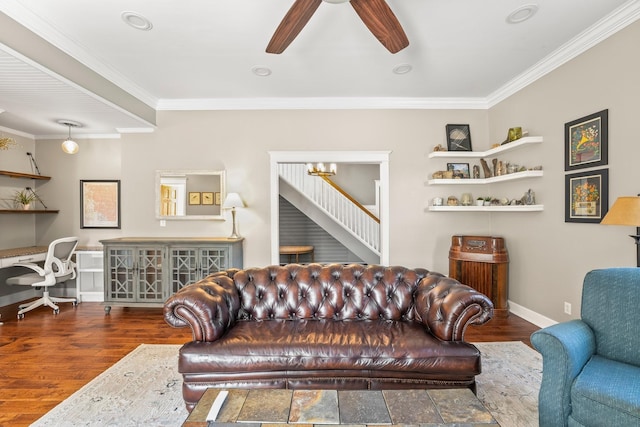 living area featuring baseboards, wood finished floors, ornamental molding, and a ceiling fan