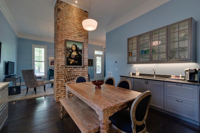 dining space with wet bar, crown molding, a brick fireplace, and dark wood-style flooring