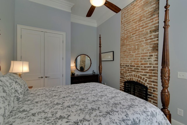 bedroom with a closet, a brick fireplace, crown molding, and ceiling fan