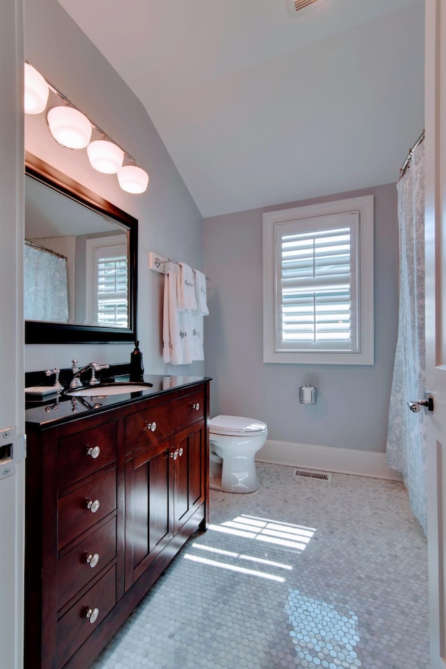 full bathroom with visible vents, toilet, tile patterned flooring, vanity, and vaulted ceiling