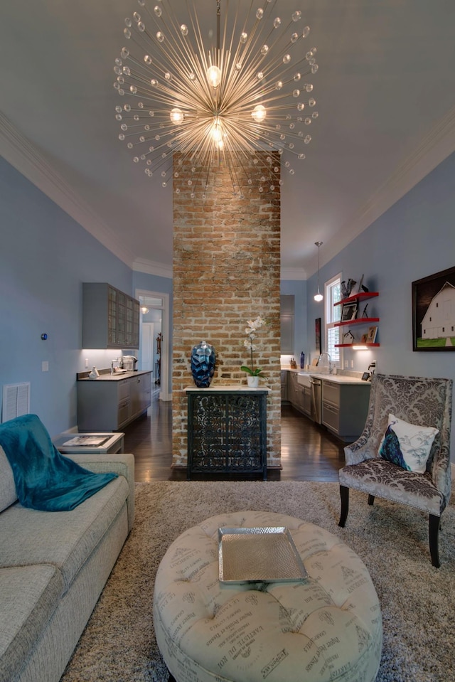 living area with visible vents, dark wood finished floors, crown molding, a brick fireplace, and a chandelier