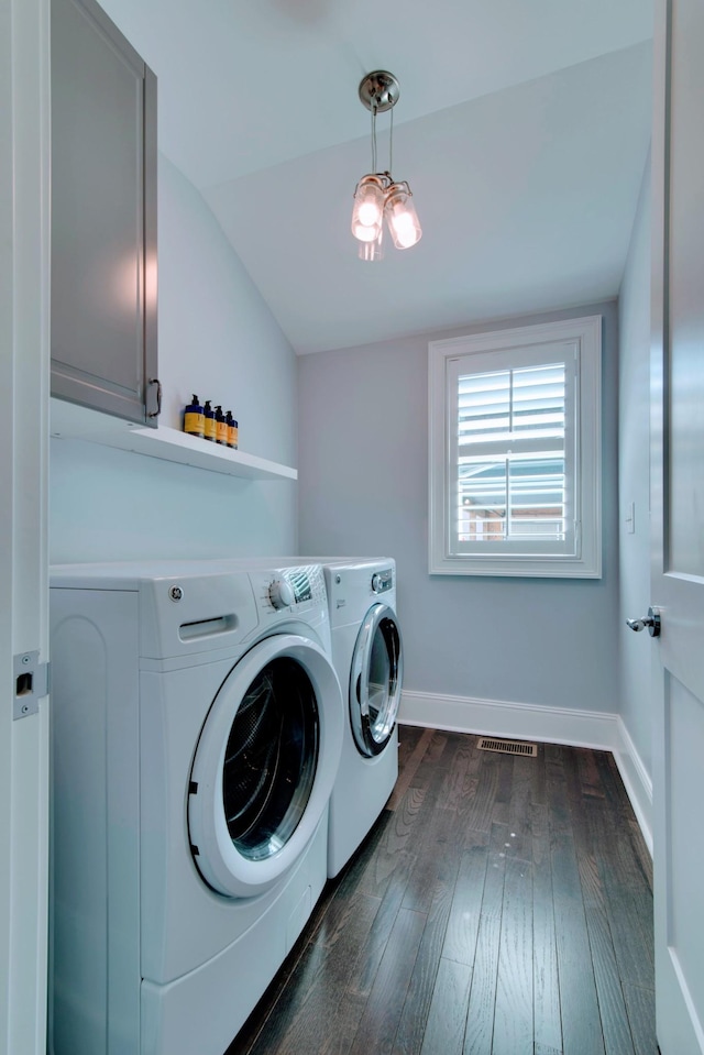 clothes washing area featuring washer and dryer, dark wood-type flooring, cabinet space, and baseboards