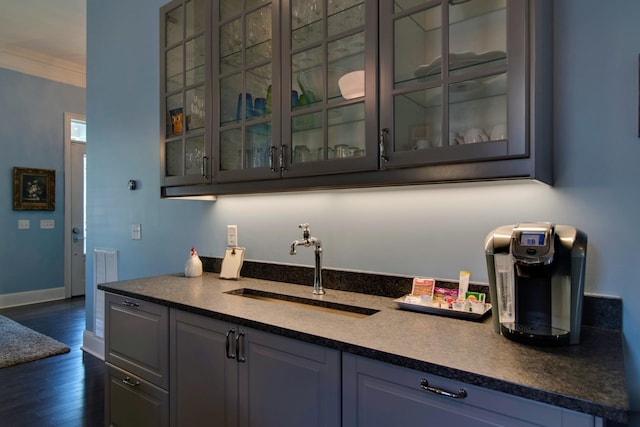 bar featuring ornamental molding, baseboards, dark wood-style flooring, and a sink