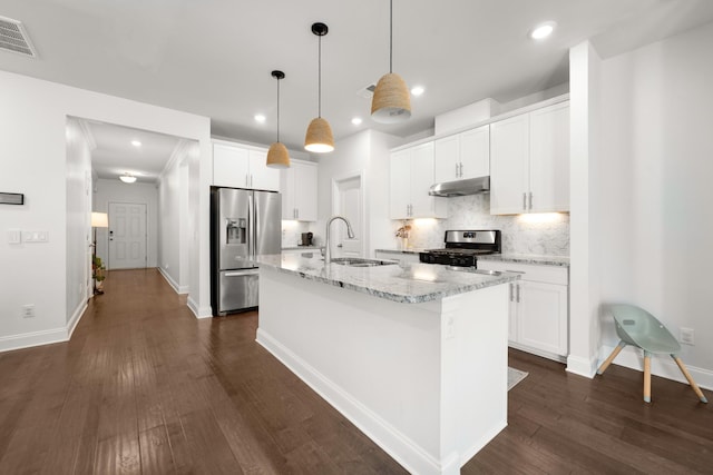 kitchen featuring visible vents, a kitchen island with sink, a sink, stainless steel appliances, and under cabinet range hood