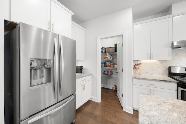 kitchen featuring dark wood-type flooring, appliances with stainless steel finishes, white cabinetry, wall chimney range hood, and tasteful backsplash