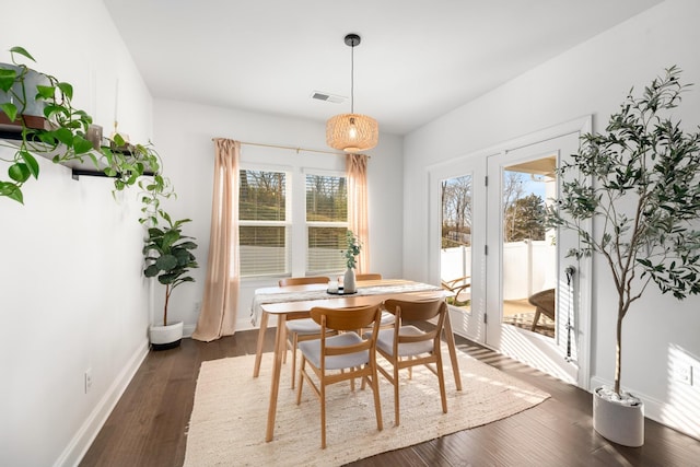 dining area featuring dark wood-style floors, visible vents, and baseboards