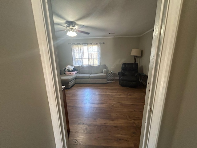 living area featuring hardwood / wood-style floors, ornamental molding, and ceiling fan