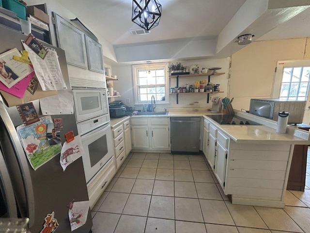 kitchen with open shelves, light countertops, appliances with stainless steel finishes, and a sink