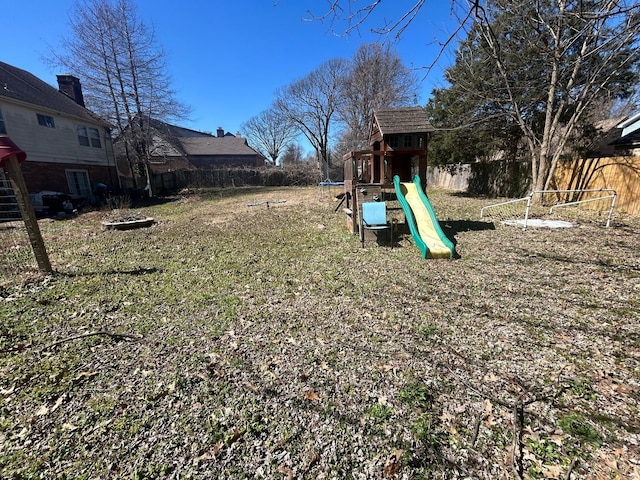 view of yard featuring fence and a playground