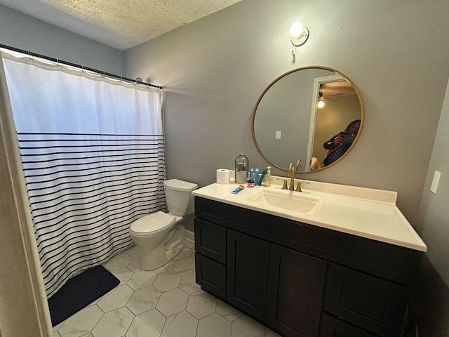 bathroom featuring toilet, a textured ceiling, and vanity