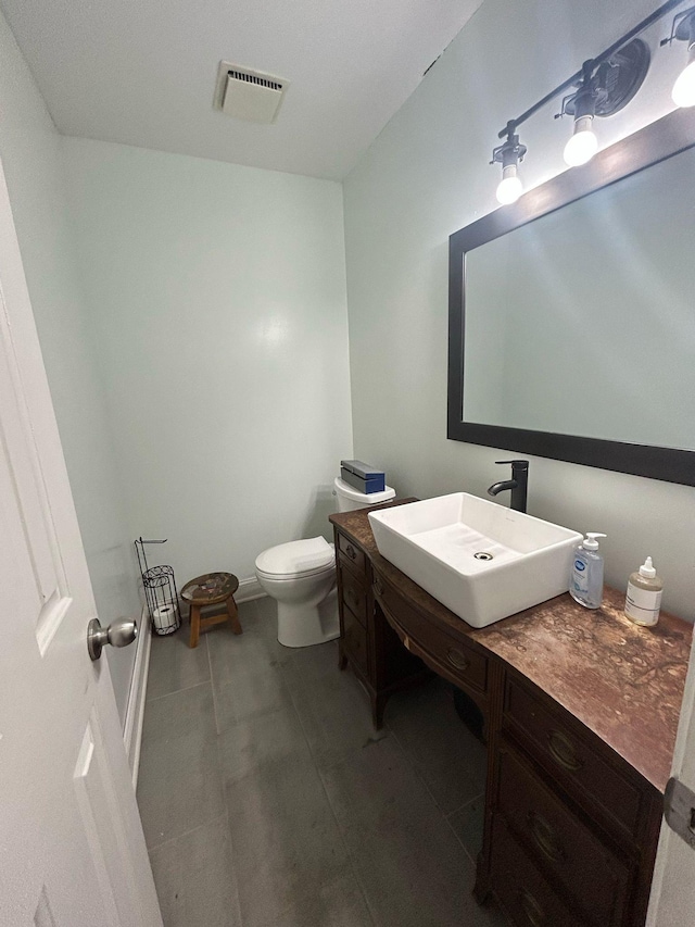 half bath with tile patterned floors, visible vents, toilet, and vanity