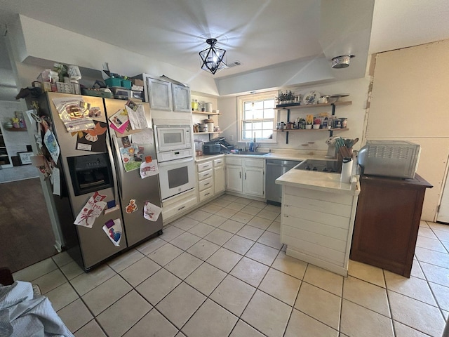 kitchen featuring light tile patterned floors, open shelves, a sink, stainless steel appliances, and light countertops