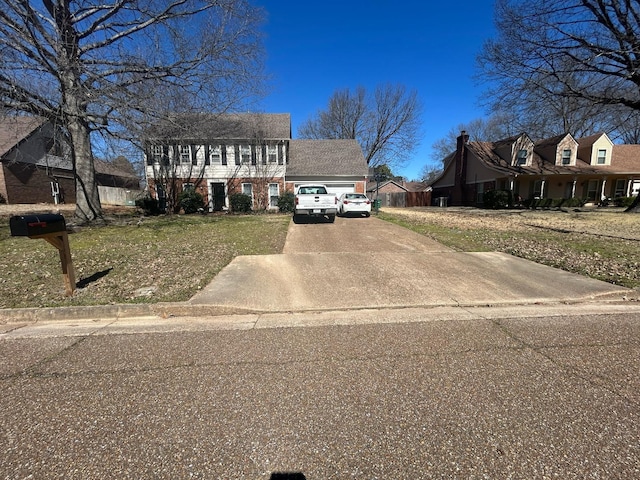 view of front of house featuring a garage, concrete driveway, and a front yard