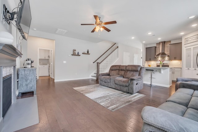 living area featuring baseboards, dark wood finished floors, recessed lighting, ceiling fan, and stairs