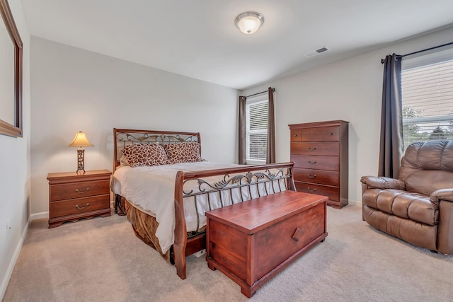 bedroom featuring multiple windows, light colored carpet, visible vents, and baseboards