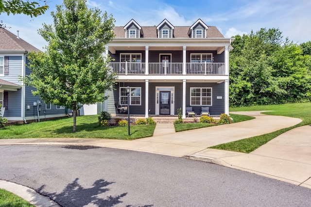 view of front of property with a balcony, covered porch, and a front lawn