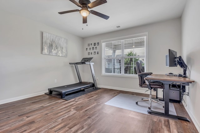 home office with visible vents, baseboards, wood finished floors, and a ceiling fan