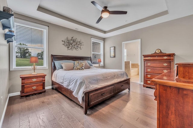 bedroom featuring a tray ceiling, visible vents, and hardwood / wood-style floors